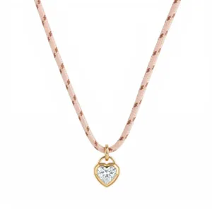 Close-up of the elegant heart-shaped crystal pendant and pink braided cord necklace detail.