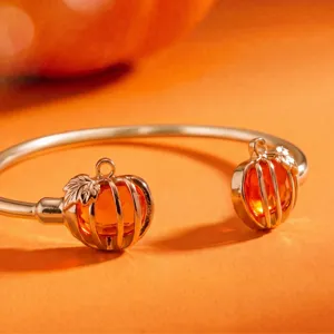 Close-up van de prachtige holle pompoen armband met sprankelende oranje edelstenen en blad details.