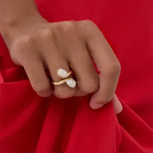 Detailopname van gouden roestvrijstalen geometrische ring met sprankelende stenen.
