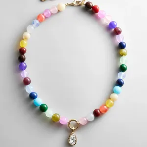 Gedetailleerd overzicht van een kleurrijke kralenketting met een fonkelende druppelhanger.