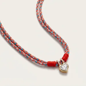 Detail view of the sparkling heart pendant and colorful braided cord necklace design.