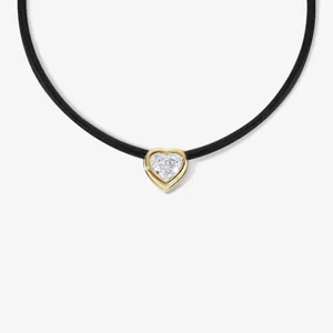 Detailaufnahme einer schwarzen Kordelkette mit Goldherz-Anhänger und funkelndem Stein.