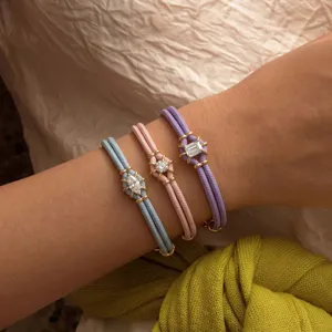 Gedetailleerd shot van macaronkleurige dubbelstrengs armbaden met zirkoonstenen.