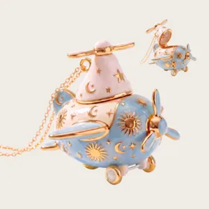 Detailed close-up view of the cute airplane pendant necklace featuring gold sun and moon.