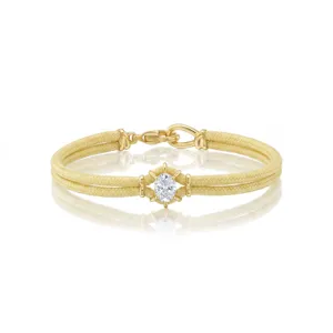 Dubbel geweven armband met een ovaal zirkonium en een elegant gouden sluitingsdetail.