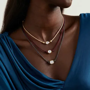 Vue de détail de colliers minimalistes en cordon multicolore avec pendentifs en zircone géométrique.