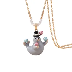 Schattige zeehond hanger ketting met handgeschilderd geëmailleerd ontwerp en speelse jongleerparels.