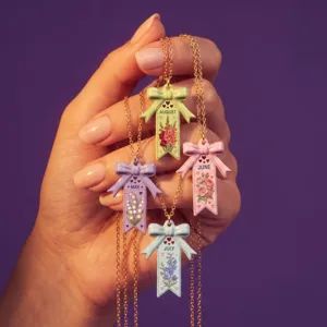 Vue en gros plan détaillée du collier noeud fleur de naissance en acier inoxydable.