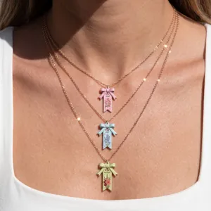 Vue rapprochée détaillée du collier triple couche en or rose avec nœud et fleurs.