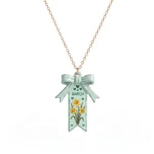 Gros plan détail du pendentif collier nœud jonquille fleur de naissance de mars en acier.