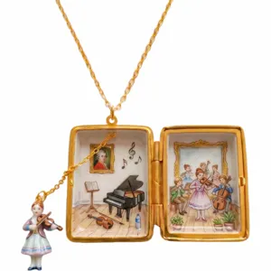 Vista detallada de un collar con medallon musical vintage con arte de piano pintado mano.