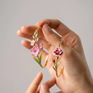Gold-plated open cuff bracelet featuring delicate pink enamel floral and leaf details.