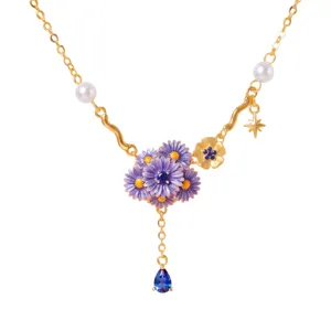 Gedetailleerd close-up van vergulde ketting met paarse emaille bloemen en blauwe hanger.