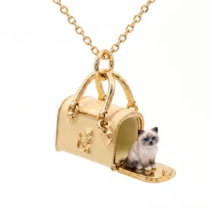 Miniatuur emaille handtas ketting met schattige blauwogige kat hanger en gouden ketting detail.