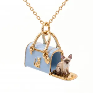 Detailopname van een vergulde minihandtas kettinghanger met een schattig kattenfiguurtje.