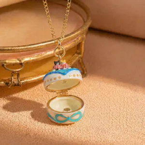 Detailed close-up of 3D cat locket necklace featuring gold chain and bow enamel design.