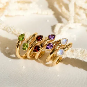 Vista detallada de anillos de acero inoxidable chapado en oro con circones de colores en pera.