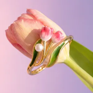 Closeup of the exquisite gold-plated tulip ring featuring pink enamel flowers and a pearl.