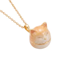 Close up view of the cute sleeping orange cat locket pendant necklace details and gold chain.