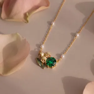 Exquisite gold necklace with green gemstone, lily of the valley and pearl details.