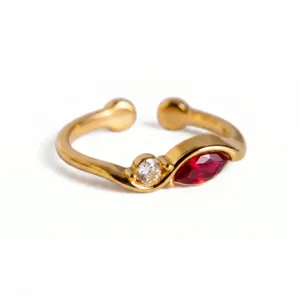 Primer plano detallado de un anillo abierto chapado en oro de 18k con piedra blanca y roja.