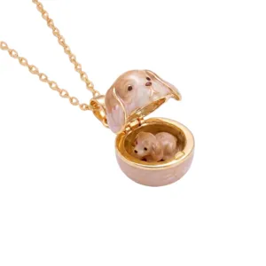 Cute puppy locket pendant necklace close-up, openable animal design with delicate gold chain.