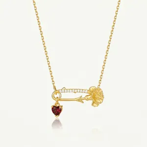 Collier épingle de sûreté doré exquis avec zircone scintillante et pendentif cœur rouge.