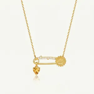 Vue détaillée du collier épingle plaqué or avec tournesol et pendentif cristal cœur jaune.