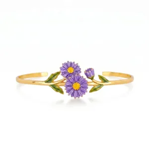 Close-up of gold-plated stainless steel open cuff bracelet with purple enamel daisy and green leaves.