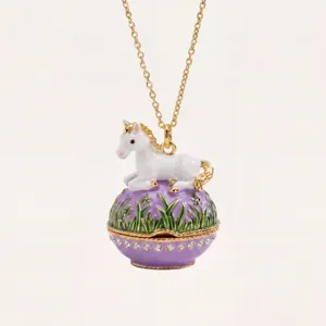 Primo piano della collana con ciondolo ad uovo di unicorno dorato e strass scintillanti.