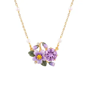 Close-up detail of the gold-plated necklace featuring purple enamel flower and purple crystal.