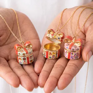 Detail view of enamel gift box pendant necklaces featuring cute miniatures like cakes and toys.