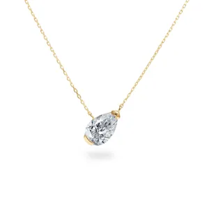 Close up of a sparkling pear cut cubic zirconia pendant necklace on a delicate gold chain.