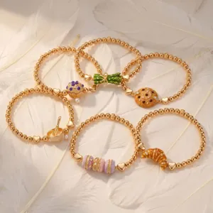 Gros plan détaillé de bracelets élastiques tendance sur le thème de la nourriture avec pendentifs.