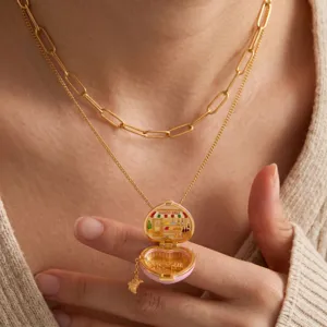 Collier médaillon cœur tendance avec mini scène en émail, chaînes dorées superposées.