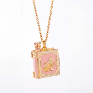 Sprookjesboek medaillon ketting met schattig elf design, roze emaille sieraden detail view.