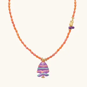Detail shot of colorful beaded fashion necklace featuring a purple fish pendant and gold accents.