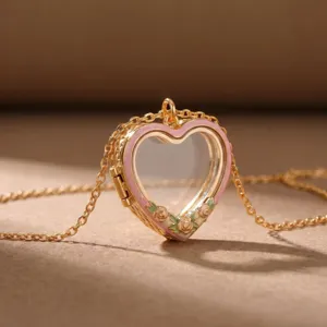 Vintage gouden hart medaillon hanger ketting met roze emailles en transparant centrum.