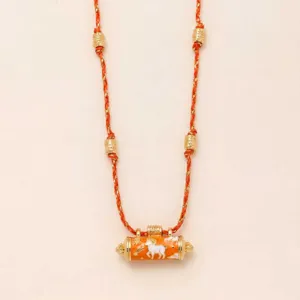 Detailed view of the stylish orange braided cord necklace featuring gold beads and a cylinder pendant.