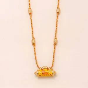 Close-up details of the fashion lion prayer wheel braided necklace with gold beads.