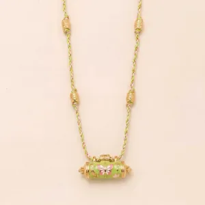 Detailed shot of gold plated braided rope necklace featuring a cylindrical butterfly pendant.