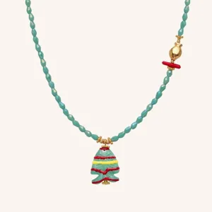 Close-up detail of the blue beaded necklace with a cute striped fish pendant and gold charms.