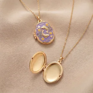 Close-up detail of a gold-plated oval locket necklace featuring purple enamel Pisces design.