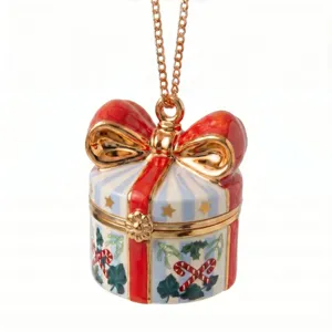 Close-up detail of Christmas gift box pendant necklace with enamel red bow and gold chain.
