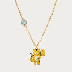 Detailweergave van de vergulde tijgerketting met een schattig bloemenhangertje en blauw kristal.