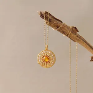 Exquisite goldene Sonnen Medaillon Halskette Detailansicht mit funkelndem Bernsteinperlen.