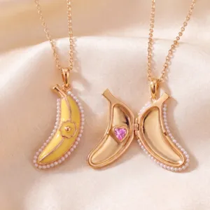 Close-up detail of the gold banana locket necklace featuring yellow enamel and pearl trim.