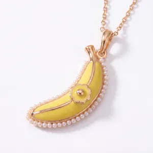 Exquisite banana pendant necklace featuring yellow enamel, pearl border, and delicate flower accent.