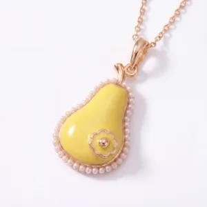 Close up detail of pear shaped pendant necklace with pearl edging and yellow enamel finish.