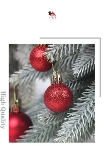 Close up shot of red Christmas baubles hanging on frosted pine tree branches for holiday decor.